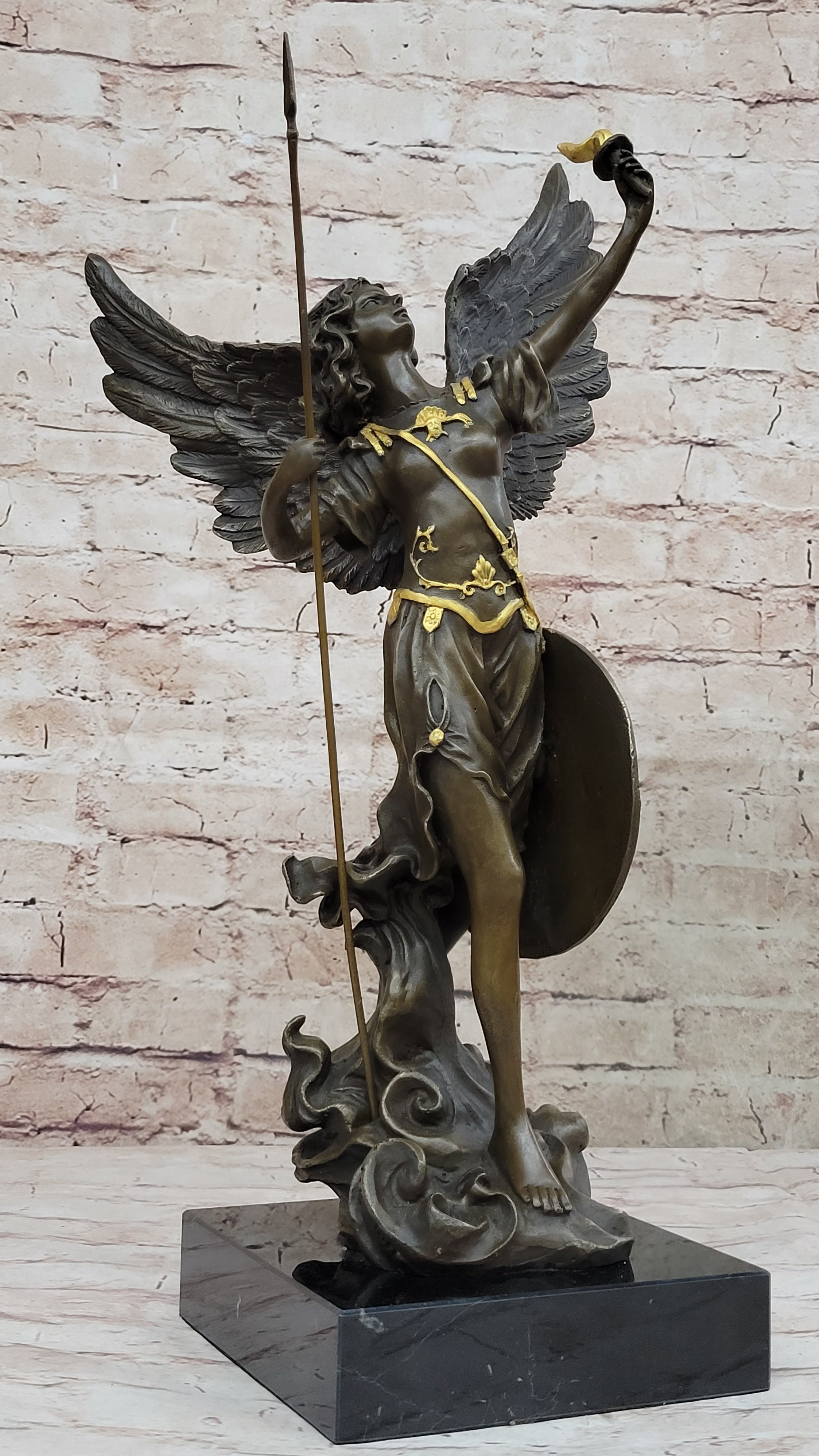 Bronze sculpture of Archangel Gabriel with a spear and shield, featuring gold accents on a marble base.